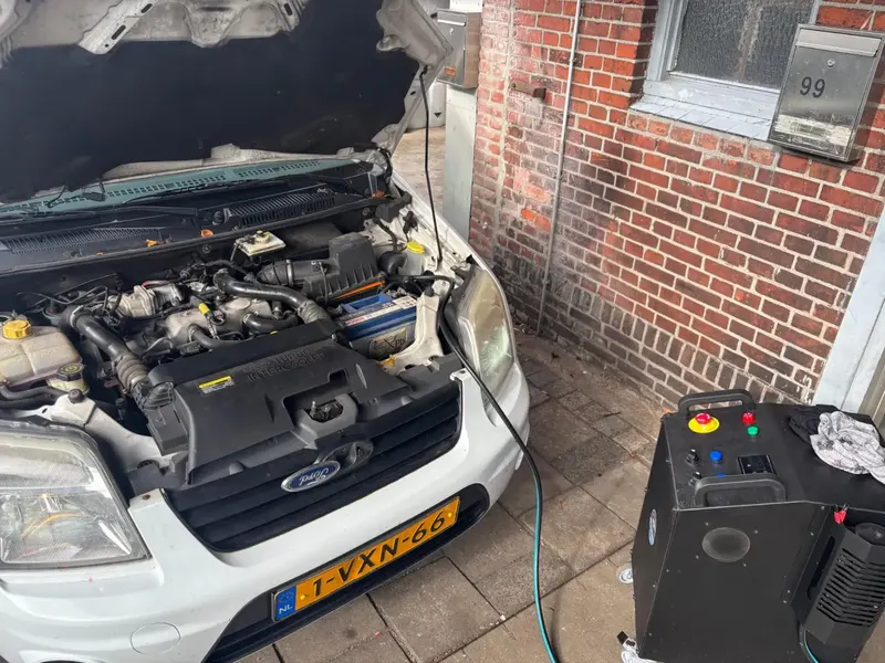 Geopende motorkap met apparatuur ernaast